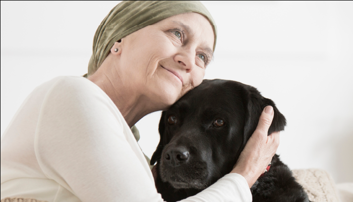 Older woman hugging black dog